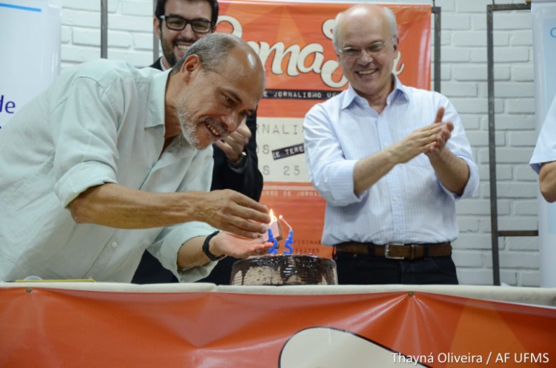 Edson Silva acende a vela do bolo de aniversário em comemoração aos 25 anos do Curso de Jornalismo UFMS